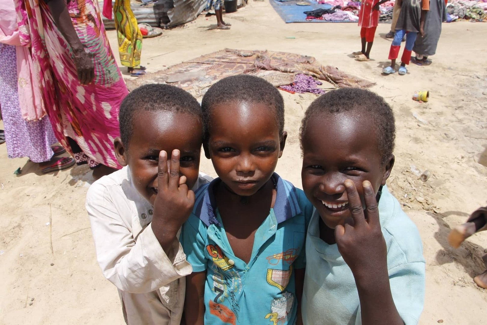 Enfants tchadiens centrafricains faisant le V de la victoire et qui sourient pour votre aide et don humanitaire